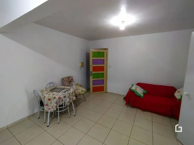 Ambiente interno de uma sala com paredes brancas e piso de cerâmica.