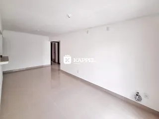 Ambiente interno amplo com piso claro e paredes brancas.
