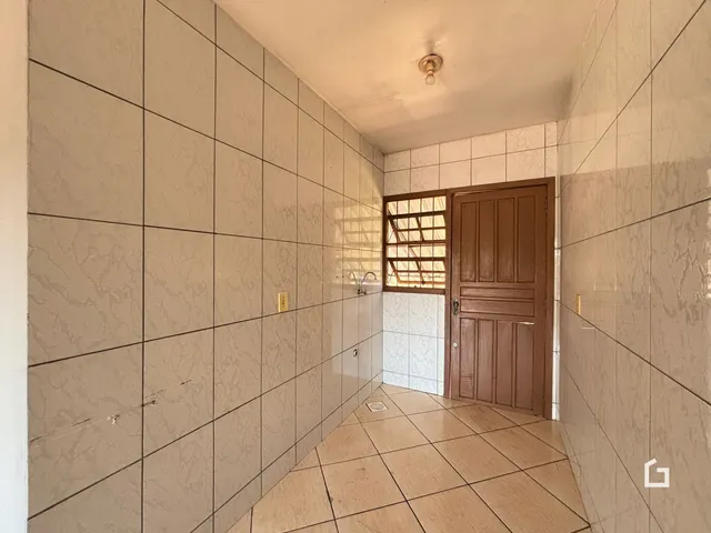 Corredor interno com piso e paredes revestidos de cerâmica.