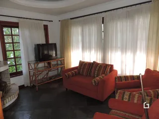 Sala de estar com sofá e janelas claras em Lajeado.