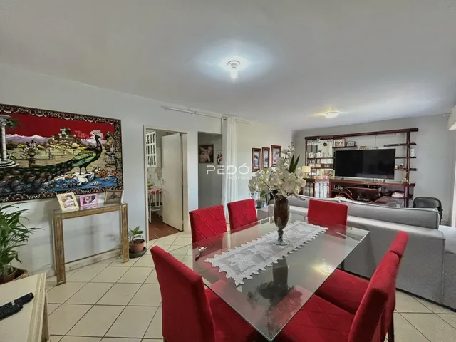 Sala de estar com mesa de jantar e sofá em um ambiente claro.