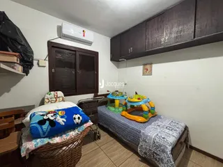 Quarto com cama e armário de madeira em um imóvel no Brasil.