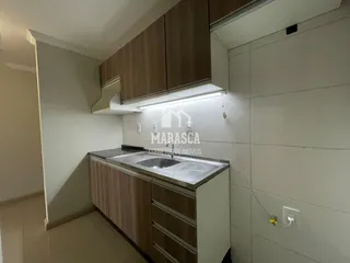 Vista da cozinha com armários de madeira e bancada.