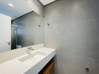 Esta é uma foto de um banheiro moderno com bancada branca.