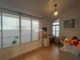 Sala de estar com grandes janelas e piso de madeira clara.