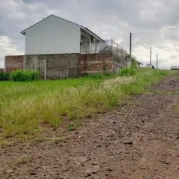 Fachada de uma construção com paredes brancas e alvenaria visível em área externa.