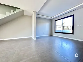 Ambiente interno moderno com paredes cinzas e piso de concreto em uma residência.