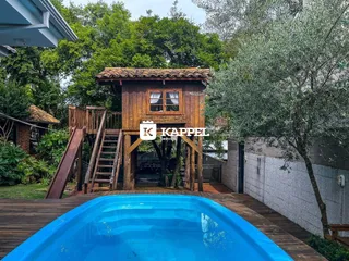 Foto da fachada de uma propriedade com piscina e estrutura de madeira em Lajeado.