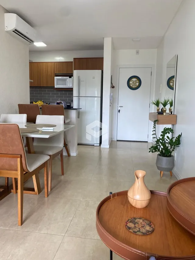 Ambiente interno com mesa de jantar e cozinha em um apartamento.