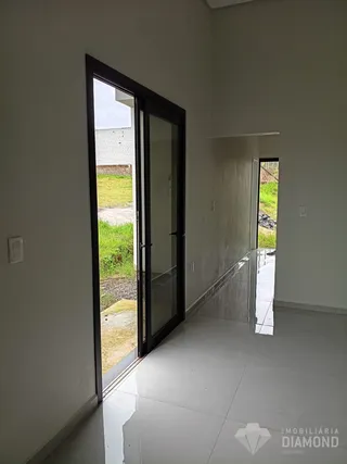 Vista de um corredor interno com porta de vidro para o exterior.