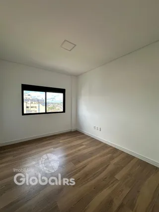 Ambiente interno com piso de madeira clara e janela grande.