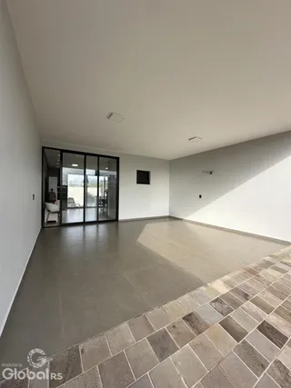 Vista ampla de uma sala com piso de cerâmica e portas de vidro.