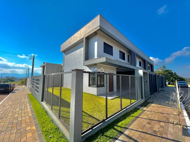 Fachada de uma casa moderna com muro e jardim em Lajeado.