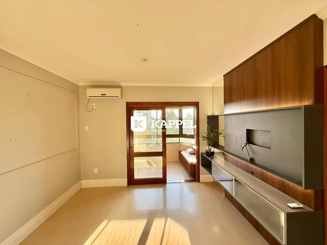 Esta é uma sala ampla com piso de madeira clara e um painel de madeira escura na parede.