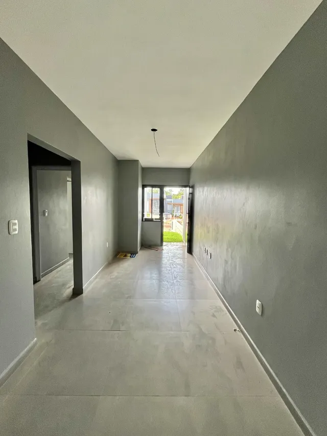 Corredor interno de uma residência com piso de cerâmica.
