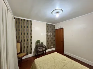 Quarto com parede decorada e piso de madeira em imóvel no Brasil.