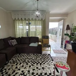 Foto da sala de estar com sofá e cortinas.