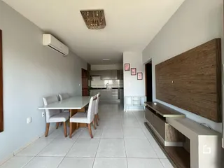 Uma sala de jantar com mesa e cadeiras em um imóvel.