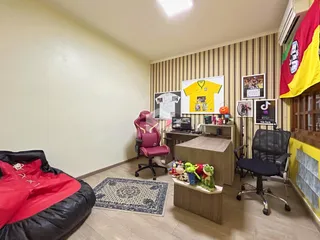 Ambiente interno de uma sala com piso de madeira e decoração de parede.