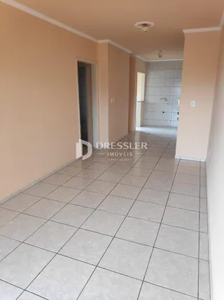 Corredor interno de uma residência com piso de cerâmica clara.