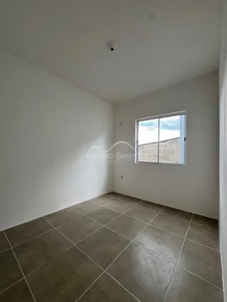 Vista interna de um cômodo com piso de cerâmica e janela.