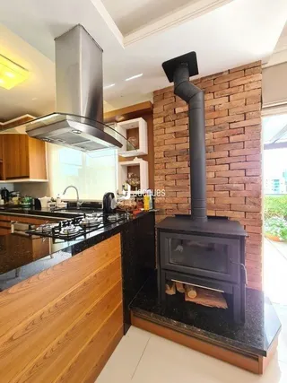 Uma cozinha com armários de madeira e parede de tijolos aparentes.