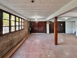 Hall de entrada com parede de tijolos expostos e piso de cerâmica.
