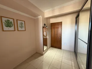 Foto de um corredor interno de uma residência com paredes claras e piso de cerâmica.