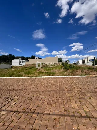 A foto mostra a fachada de uma propriedade com um terreno gramado e pavimentado.