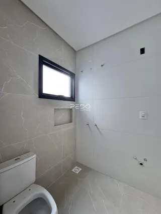 Foto de um banheiro moderno com piso de cerâmica e paredes claras.