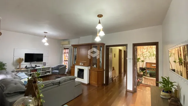 Sala de estar com piso de madeira e lareira em uma residência.
