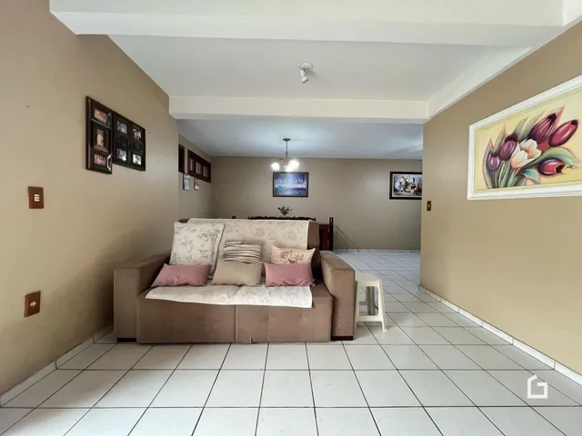 Sala de estar com sofá e piso de cerâmica claro.