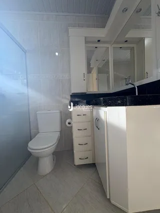 Foto de um banheiro moderno com azulejos brancos e bancada escura.