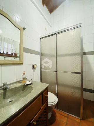 Foto de um banheiro com revestimento cerâmico e bancada de granito.