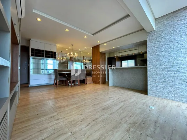 Ambiente interno de uma sala de estar com piso de madeira clara e decoração moderna.