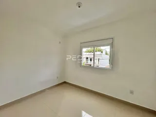 Foto de um cômodo interno com paredes brancas e piso claro.