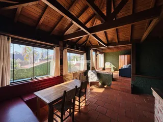 Ambiente interno com teto de madeira e vista para a paisagem externa.