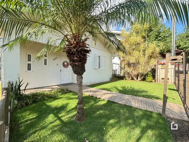 Fachada de uma casa em Lajeado, Brasil, com jardim gramado e palmeira.