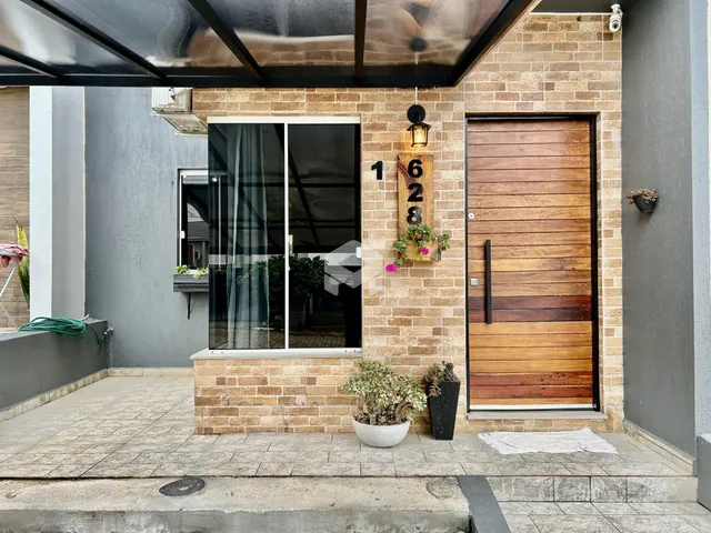 Fachada de uma residência com porta de madeira e janela no exterior.