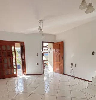 Interior de uma sala com piso de cerâmica e portas de madeira.