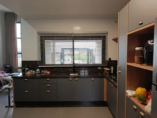 Vista da cozinha com armários cinzas e bancadas escuras em Lajeado.