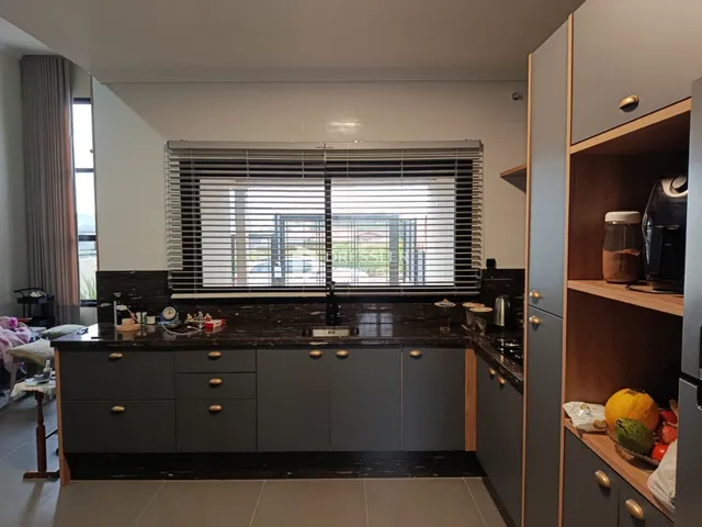 Vista da cozinha com armários cinzas e bancadas escuras em Lajeado.