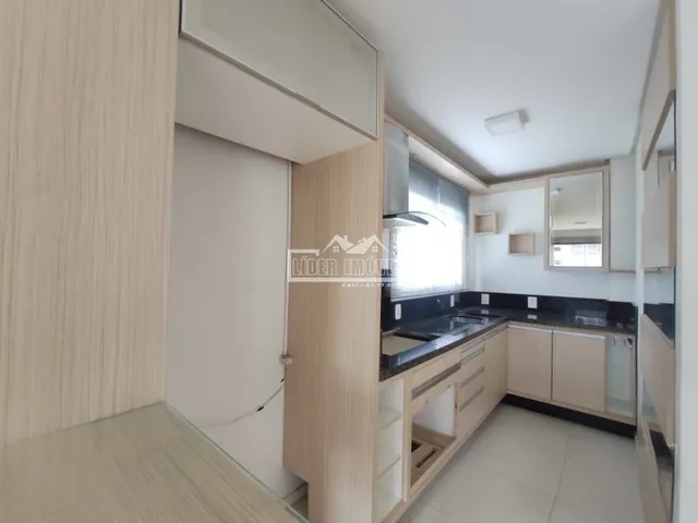 Foto de uma cozinha moderna com armários e bancada escura.