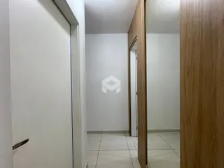 Hall de entrada com paredes brancas e piso claro.