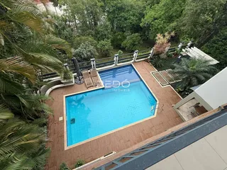 Vista aérea de uma piscina e área externa com vegetação exuberante.