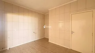 Interior de um corredor com paredes brancas e piso de cerâmica.