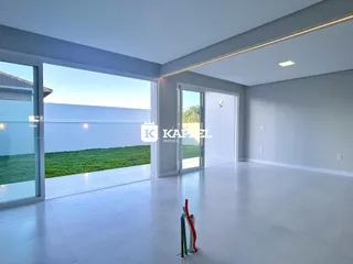 Sala de estar com grandes portas de vidro que oferecem vista para um gramado verde.