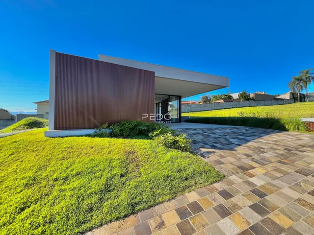 Fachada de uma casa moderna em Lajeado, Brasil, com jardim e área pavimentada.
