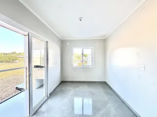 Vista interna de um ambiente com piso de cerâmica e porta de vidro.