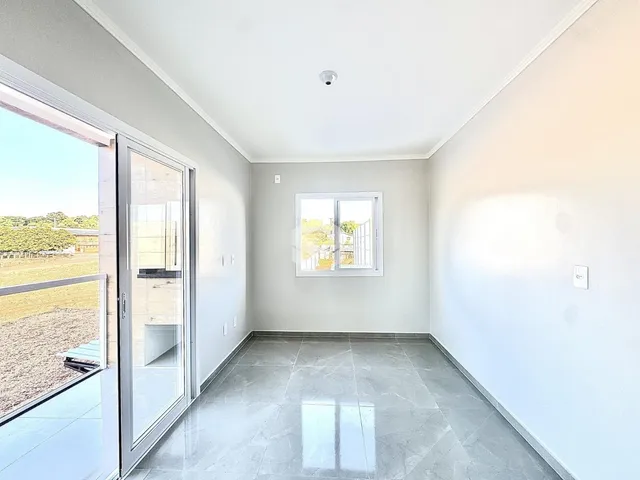 Vista interna de um ambiente com piso de cerâmica e porta de vidro.